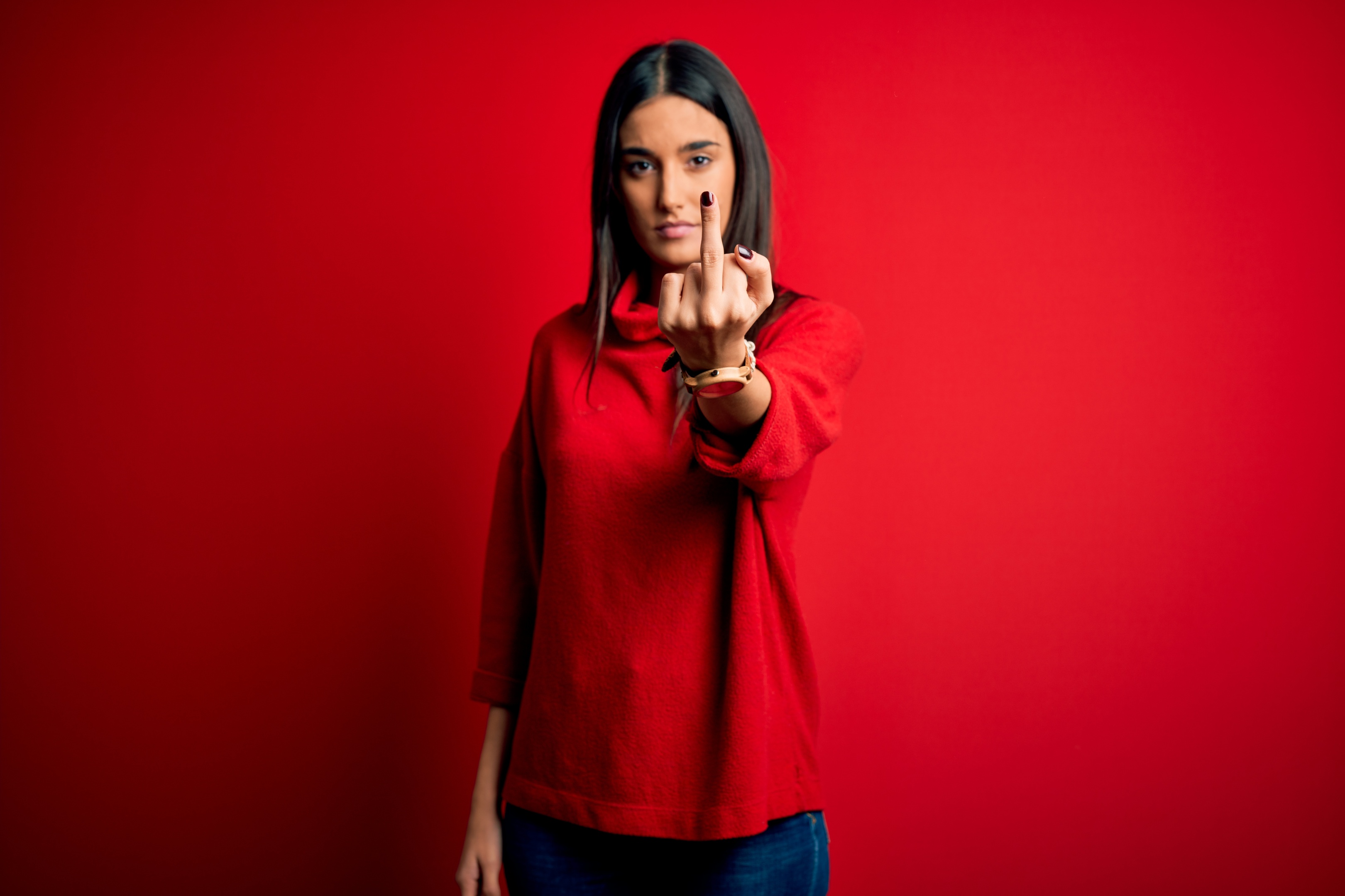 Angry Young woman giving the middle finger to the world
